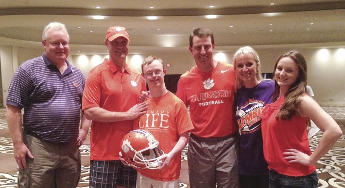 Rion Holcombe (center), who recently was accepted into the ClemsonLIFE programs, and his family with President Clements and Coach Swinney.